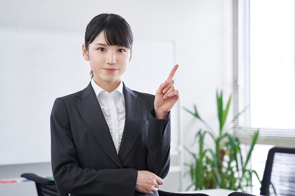 オフィスで指差しで説明をする日本人女性ビジ